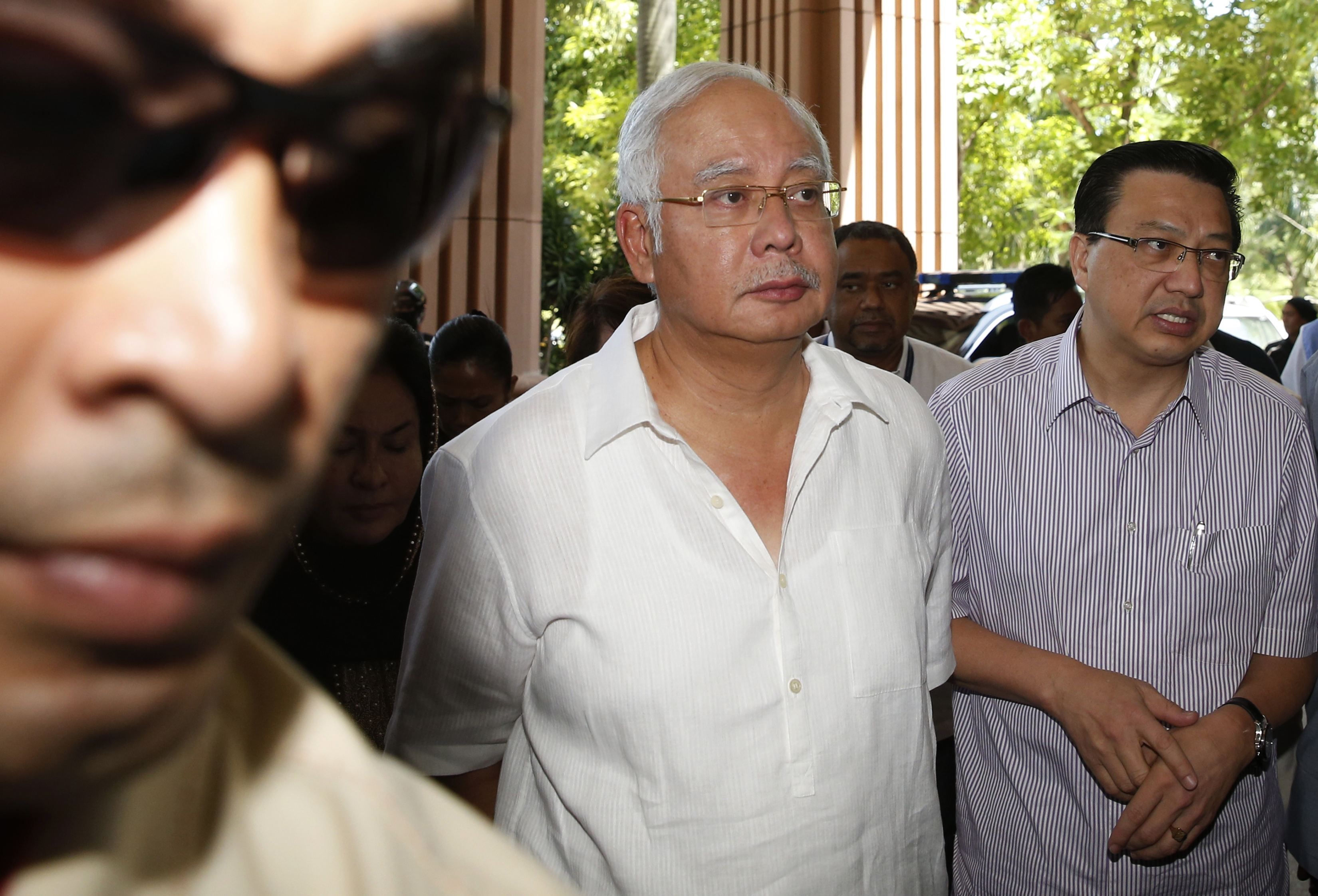 Malaysian Prime Minister Datuk Seri Najib Razak (centre) arrives at a hotel next to Transport Minister Datuk Seri Liow Tiong Lai (right) to visit bereaved families of passengers killed on Malaysia Airlines Flight MH17, in Putrajaya July 19, 2014. u00e2u20acu201d Reut