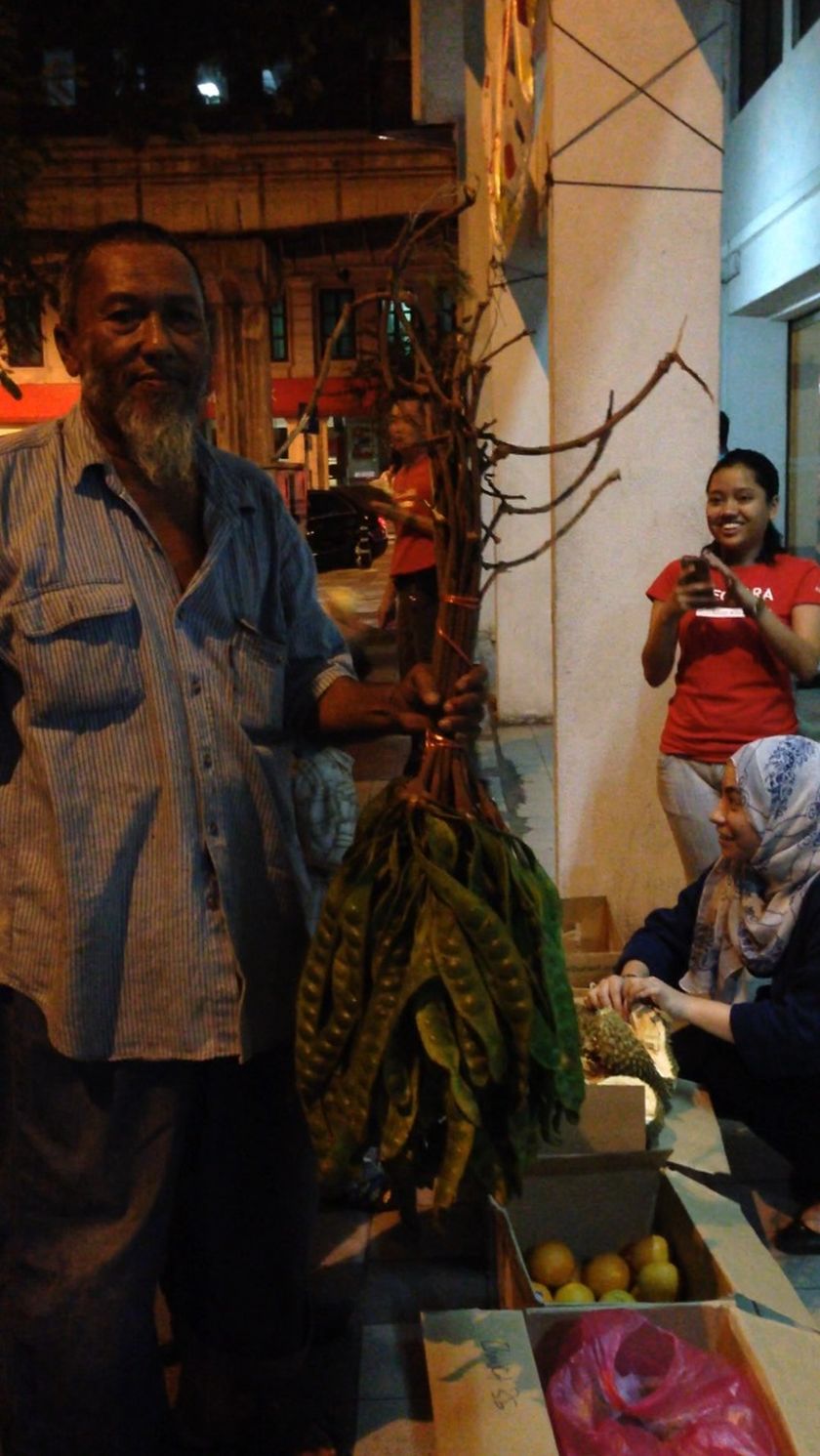 Syed Mokhtar Abdul Rahman poses with some petais which were left over from his sales in front of Kechara Soup Kitchen volunteers, July 6, 2014. — Picture by Melissa Chi
