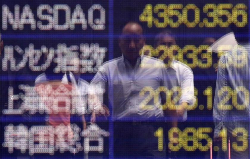 A man is reflected on an electronic board showing major Asian stock market indices outside a brokerage in Tokyo June 25, 2014. u00e2u20acu201d Reuters pic