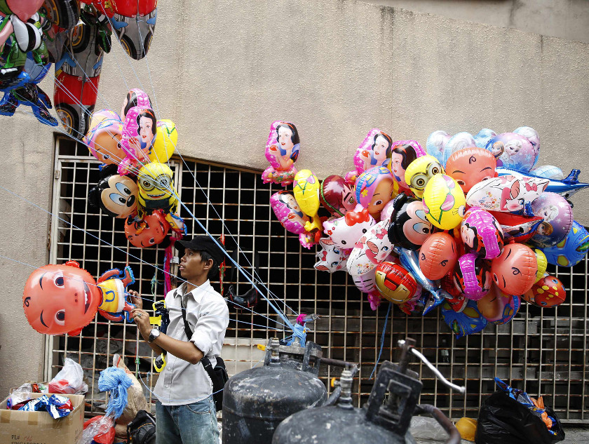 A balloon seller blows up balloons to sell to people shopping before celebrating Hari Raya Aidilfitri, which marks the end of Ramadan, in Kuala Lumpur July 27, 2014. u00e2u20acu201d Reuters pic