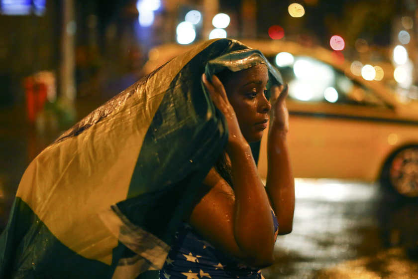 A Brazil football fan walks in the rain after watching a broadcast of their team's loss against Germany in their 2014 World Cup semi-final match, in Rio de Janeiro July 8, 2014. u00e2u20acu201d Reuters pic
