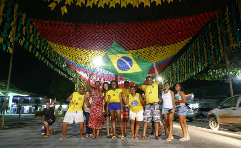 People display a Brazilian national flag as they pose under a giant German national flag after the World Cup semi-final between Germany and Brazil, in the town of Santa Cruz Cabralia, north of Porto Seguro late July 8, 2014. u00e2u20acu201d Reuters pic