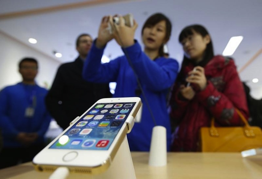 A staff of a China Mobile shop explains a function of the iPhone 5s to a customer in Beijing January 17, 2014.u00c2u00a0u00e2u20acu201d Reuters pic