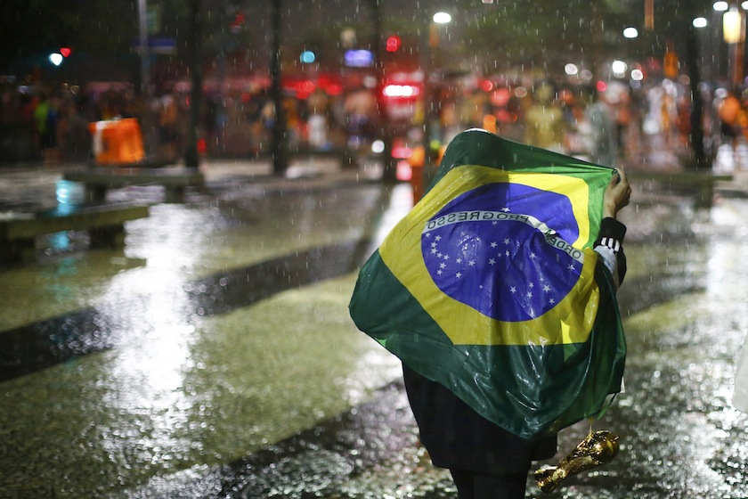 A Brazil fan walks in the rain after watching a broadcast of their team's loss against Germany in their 2014 World Cup semi-final match, in Rio de Janeiro July 9, 2014.   u00e2u20acu201d Reuters pic