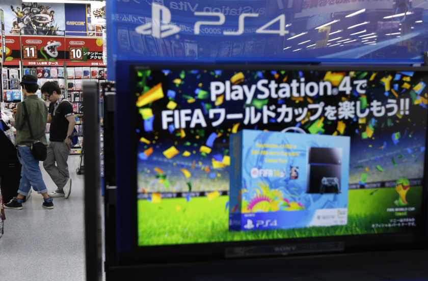 Shoppers browse for video games near a poster advertising a FIFA football video game played on Sony Corp's PlayStation 4 console, at an electronics retail store in Tokyo June 10, 2014. u00e2u20acu201d Reuters pic