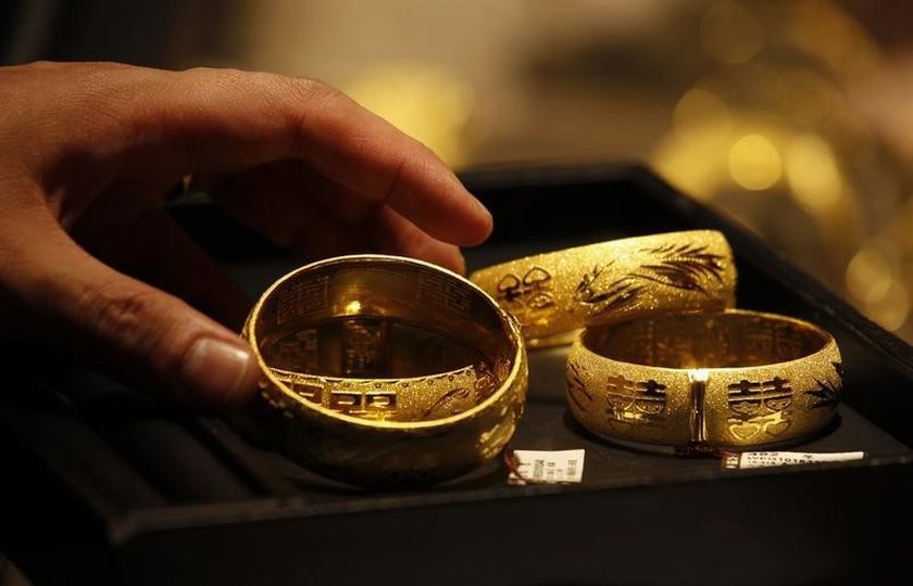 A shop attendant shows two pairs of 24K gold bracelets for Chinese weddings to a customer inside a jewellery store at Hong Kongu00e2u20acu02dcs Tsim Sha Tsui shopping district April 24, 2013. u00e2u20acu201d Reuters pic
