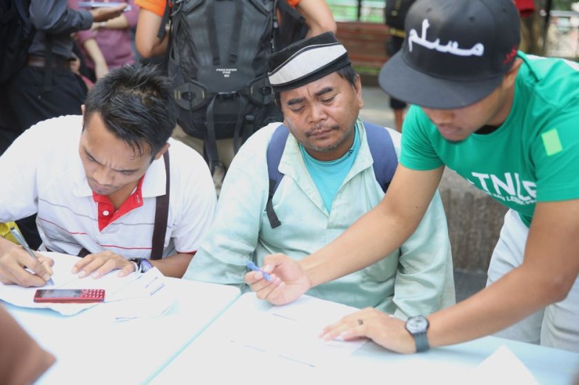A volunteer helps a homeless person fill up the application form for MyKad, July 20, 2014.u00e2u20acu201d Picture by Choo Choy May