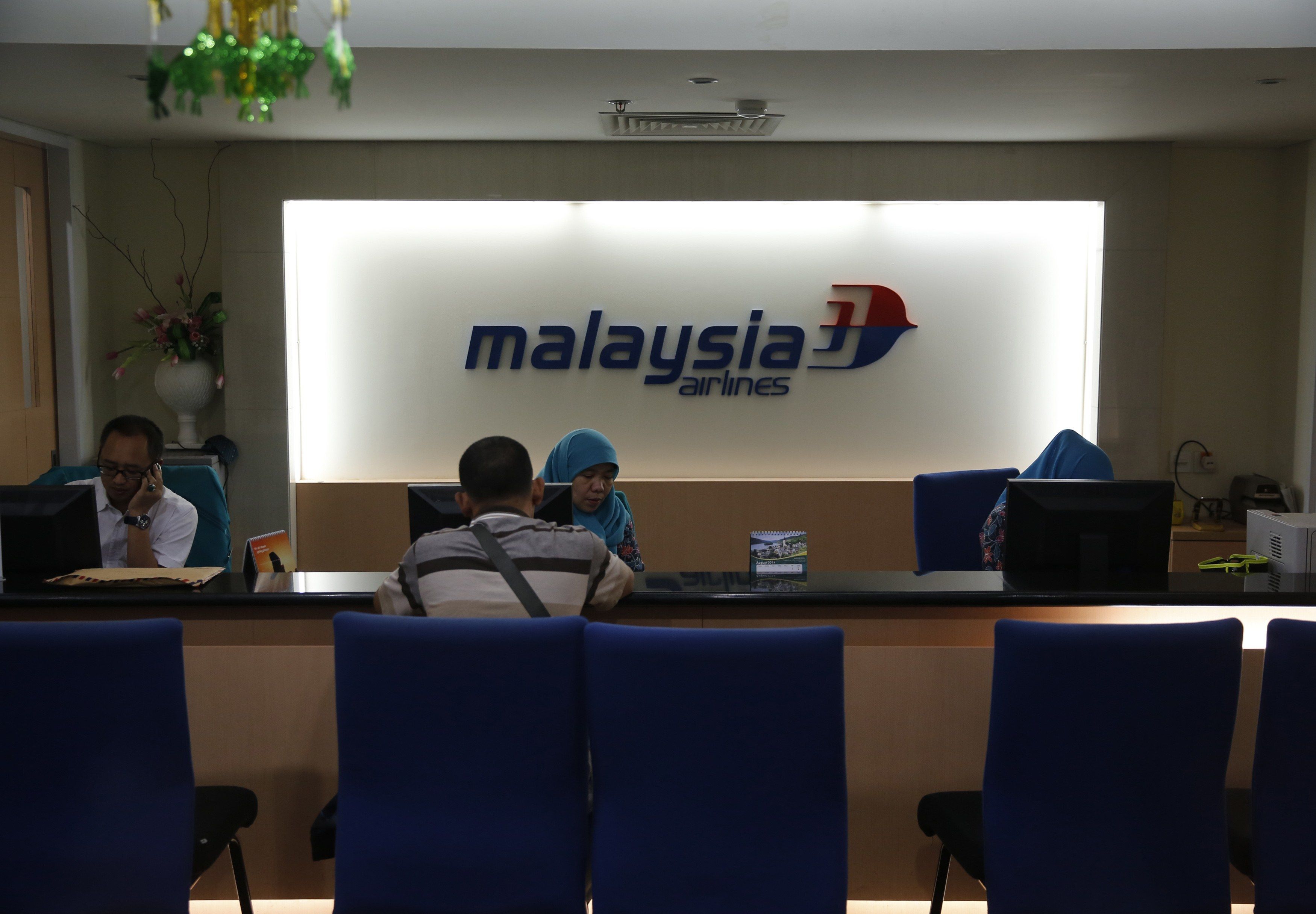 A customer service representative at the Malaysia Airlines ticket office serves a customer in Jakarta July 18, 2014. u00e2u20acu201d Reuters pic