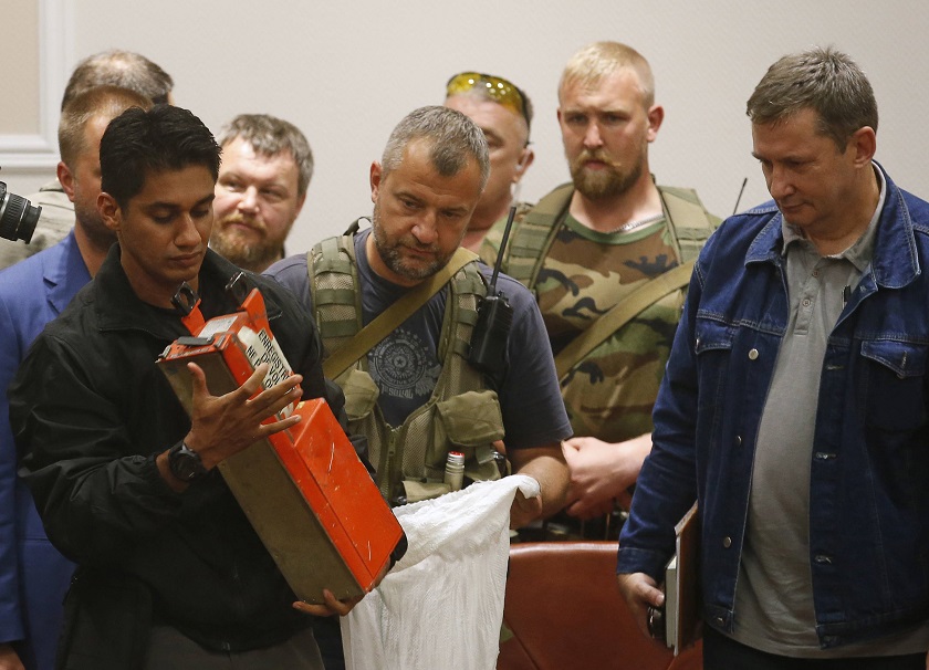 A Malaysian expert (left) examines a black box belonging to Malaysia Airlines flight MH17 during its handover from pro-Russian separatists, in Donetsk July 22, 2014. u00e2u20acu2022 Reuters pic