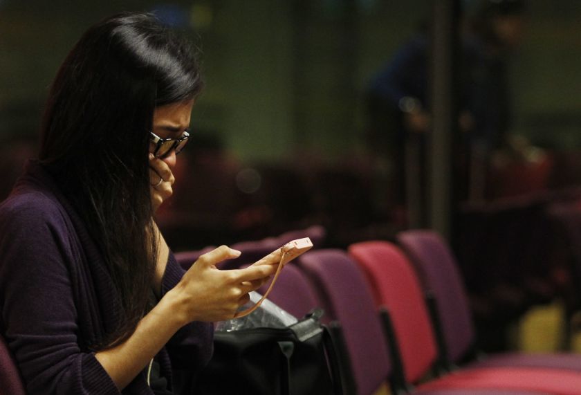 A Malaysian woman who had a relative on board the Malaysian Airlines MH17 reacts to messages on her mobile phone as she waits to travel to Kuala Lumpur International Airport from Singapore's Changi Airport July 18, 2014. u00e2u20acu2022 Reuters pic