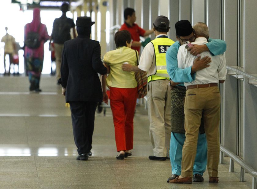 A man (in blue), whose family was on board Flight MH17, consoles another man who had just arrived with his wife to receive confirmation that their daughter's family was on the plane, at KLIA in Sepang July 18, 2014. u00e2u20acu201d Reuters pic