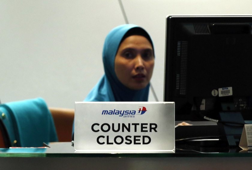 A staff member sits behind a closed Malaysia Airlines desk at Kuala Lumpur International Airport July 18, 2014.u00c2u00a0u00e2u20acu201d Reuters pic