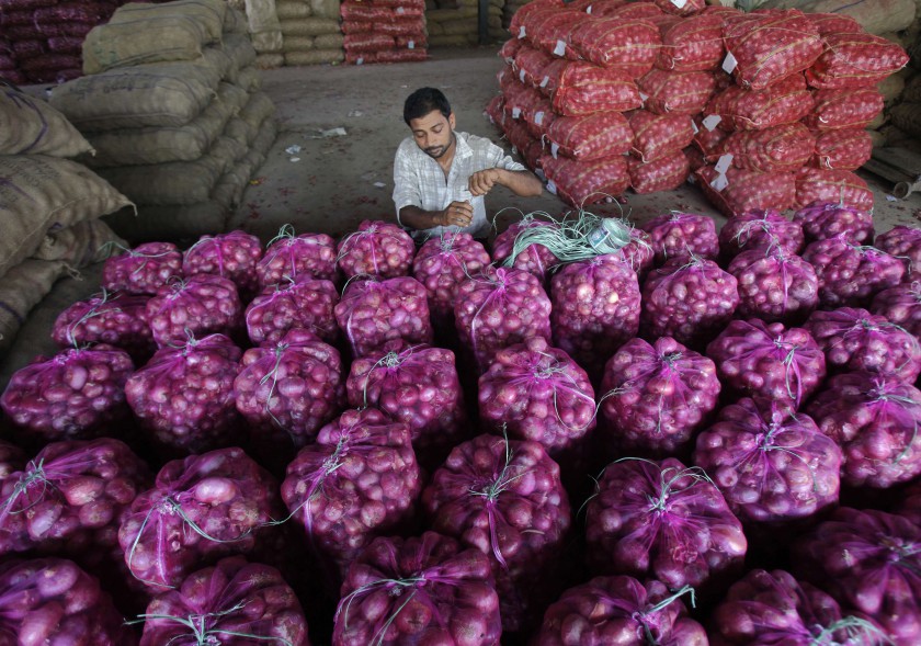 A worker packs onion bags at a vegetable and fruit wholesale market in the northern Indian city of Chandigarh July 9, 2014. u00e2u20acu201d Reuters pic