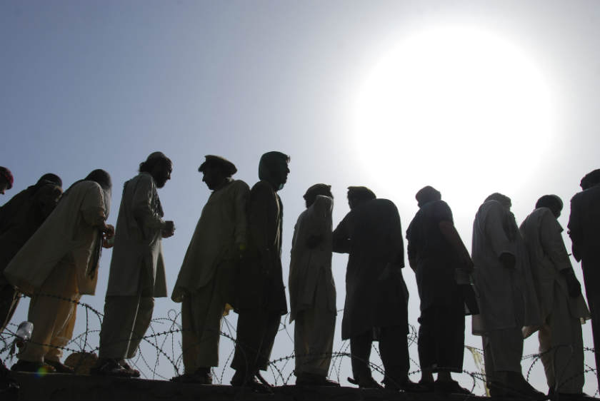 Men, fleeing from the military offensive against Pakistani militants in North Waziristan, queue to get relief handouts from a distribution point for IDPs in Bannu. u00e2u20acu201d Reuters pic
