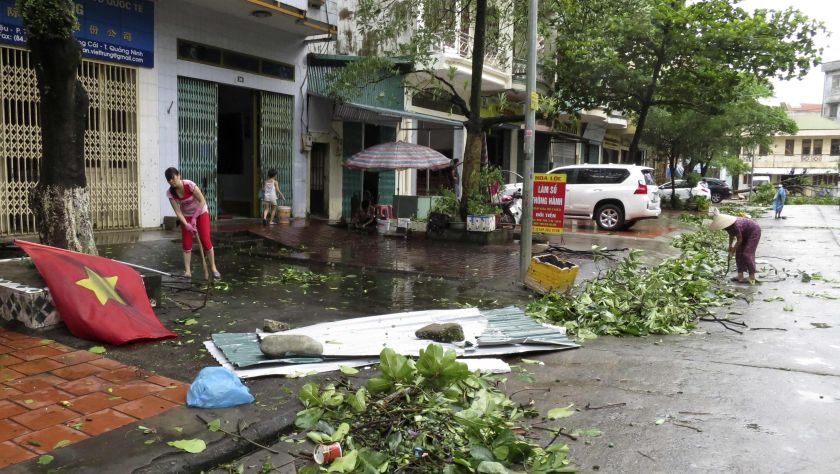 Shop owners clear felled tree branches from the street after heavy rainfall from Typhoon Rammasun in Mong Cai July 19, 2014. u00e2u20acu2022 Reuters pic