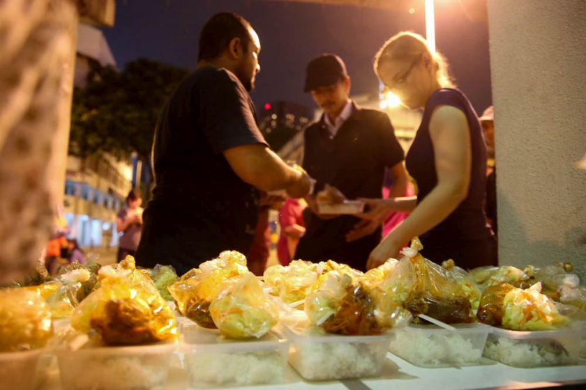 Volunteers from Need to Feed the Need soup kitchen handing out food to the homeless and urban poor at Jalan Tuanku Abdul Rahman. u00e2u20acu201d Picture by Choo Choy May