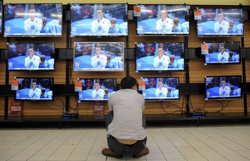 A man crouches in front of television sets broadcasting recorded footage of 2014 Brazil World Cup group D match between England and Uruguay, at a home appliances store in Wuhan, Hubei province June 20, 2014. u00e2u20acu201d Reuters pic