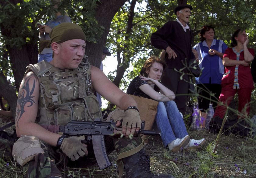 Ukrainian army soldier from battalion u00e2u20acu02dcAydaru00e2u20acu2122 guards local residents as they leave the village of Metalist near the eastern Ukrainian city of Luhansk July 11, 2014. u00e2u20acu2022 Reuters picn