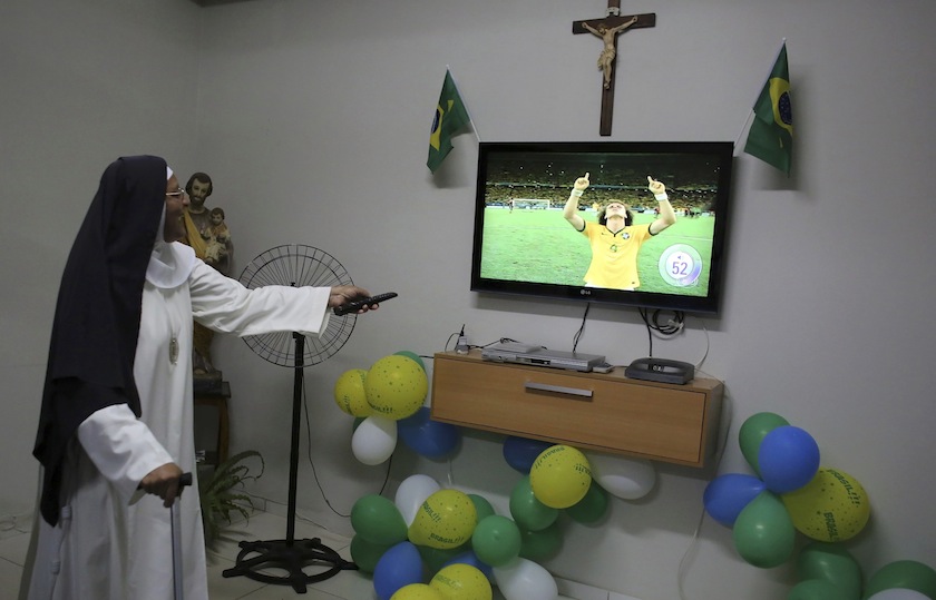 A nun from the enclosed monastery of Imaculada Conceicao watches as Brazil's David Luiz celebrates at the end of the 2014 World Cup quarter-finals between Brazil and Colombia in Piratininga, in the state of Sao Paulo, July 5, 2014.u00c2u00a0u00e2u20acu201d Reuters pic