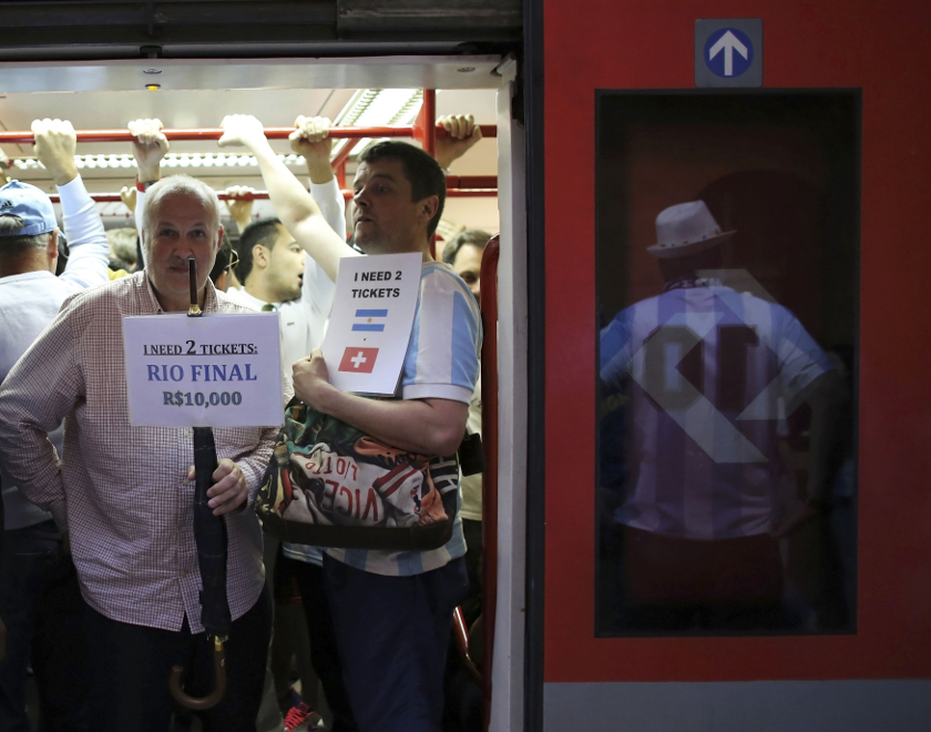 Football fans hold up signs seeking to buy tickets for matches as they travel on a train towards the Corinthians arena at the Luz Station before the 2014 World Cup match between Argentina and Switzerland in Sao Paulo July 1, 2014. u00e2u20acu201d Reuters pic