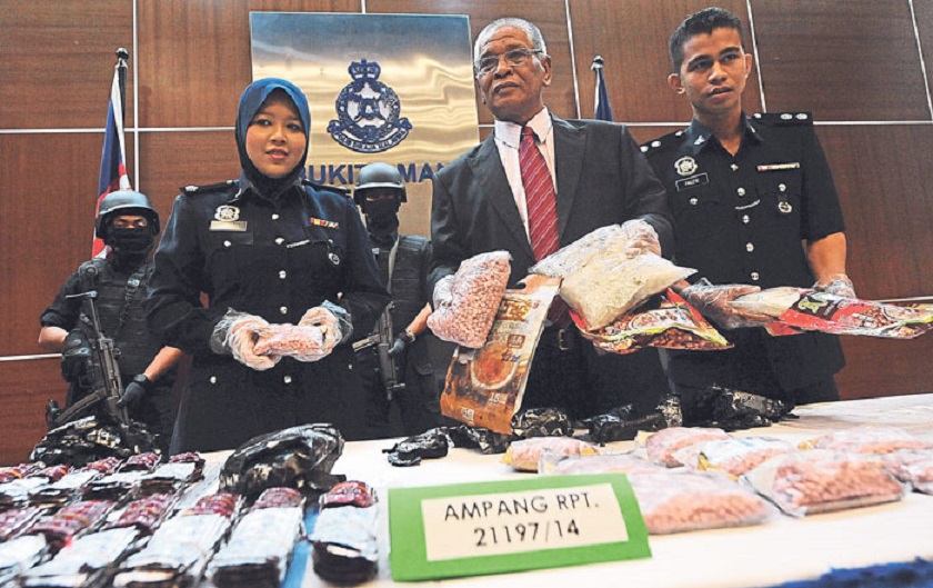 Noor Rashid (centre) shows the drugs that were seized. u00e2u20acu201d Picture by Zuraneeza Zulkifli