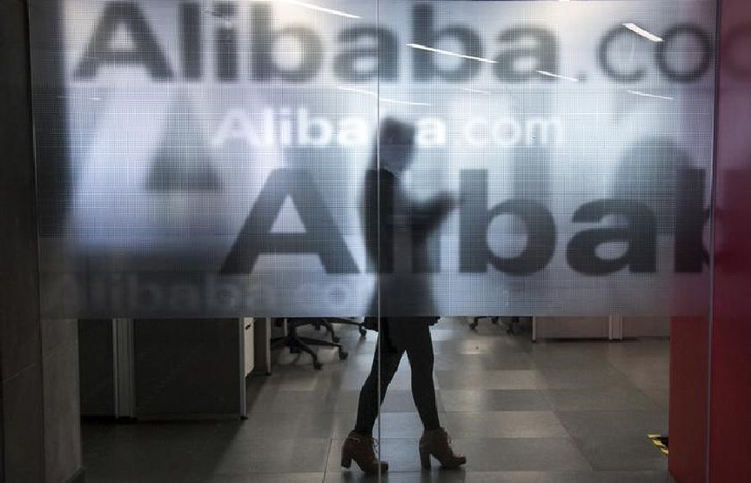 An employee is seen behind a glass wall with the logo of Alibaba at the company's headquarters on the outskirts of Hangzhou, Zhejiang province, April 23, 2014 Reuters