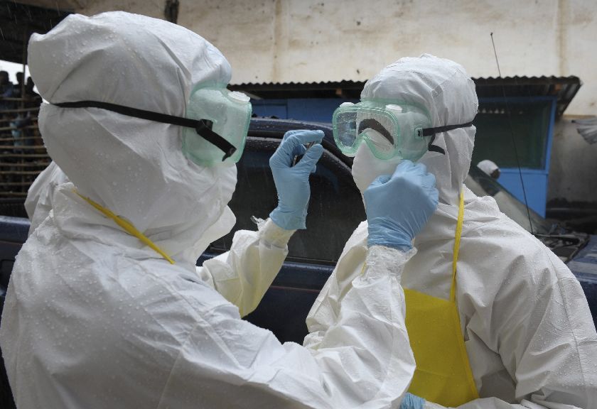 Health workers prepare themselves to carry an abandoned dead Ebola victim at Duwala market in Monrovia August 17, 2014 Reuters