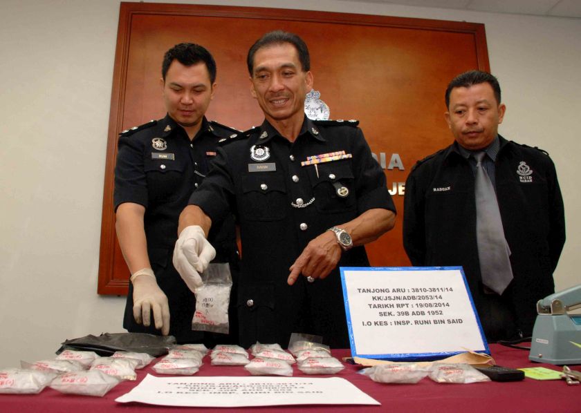 State Narcotics Department Chief Superintendent Abdul Rahim Dolmat (centre) showing the syabu and other items seized from a drug trafficking raid which also saw a 24-year-old local man arrested. u00e2u20acu201d Picture by Julia Chan