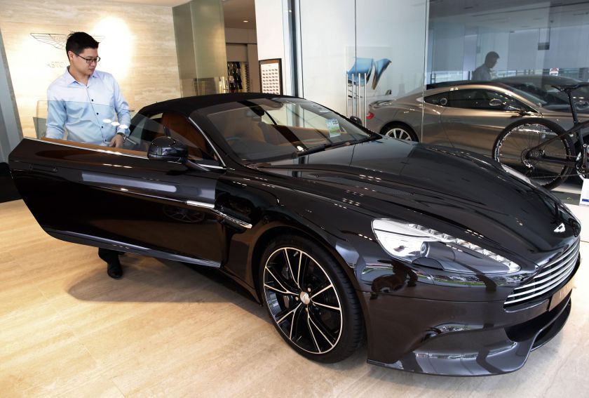 Sales Manager Raymond Liu gets into an Aston Martin Vanquish at their showroom in Singapore August 1, 2014. u00e2u20acu201d Reuters pic