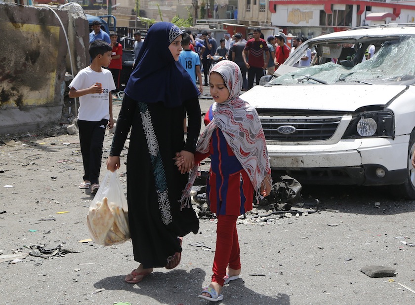 Girls walk past the site of a car bomb attack in Baghdad's Sadr City, August 1, 2014. u00e2u20acu201du00c2u00a0Reuters pic