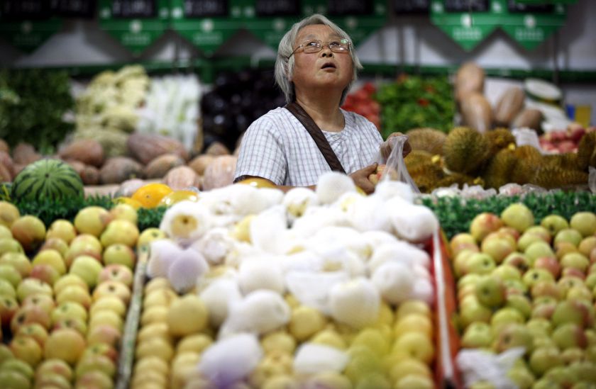A customer looks up at price tags at a supermarket in Ma'anshan, Anhui province, August 9, 2014. China posted mild consumer inflation well below the annual target in July, giving authorities room to further relax monetary policy. u00e2u20acu201d Reuters pic