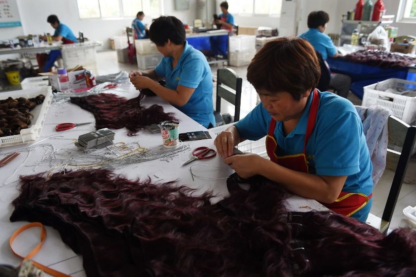 This photo taken on July 28, 2014 shows workers preparing hair extensions at the ANNA factory in Taihe, in China's eastern Anhui province. u00e2u20acu201d AFP pic