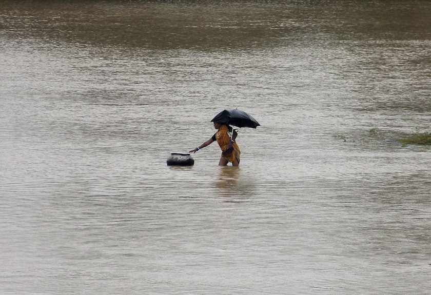 A villager reaches out to a pot drifting away from her in a flooded area of Kendrapara district after heavy monsoon rains in the eastern Indian state of Odisha August 9, 2014. u00e2u20acu201d Reuters pic