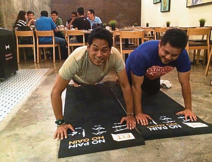 Youth and Sports Minister Khairy Jamaluddin (left) had, on Monday, posted on Twitter a picture of himself and an unidentified individual performing push-ups at a restaurant in Publika. — Picture taken from @KhairyKJ
