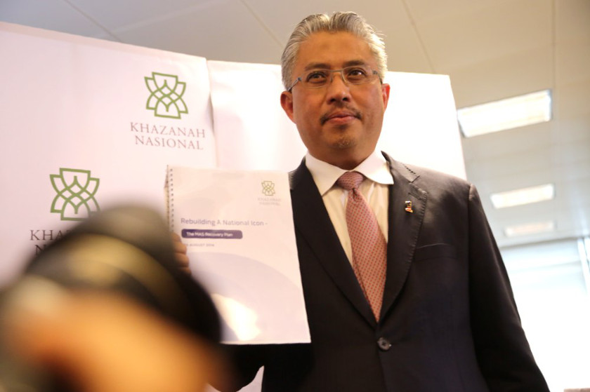 Khazanah's Managing Director Tan Sri Azman Mokhtar holds a copy of the 12-point MAS recovery plan at a special briefing in Kuala Lumpur, on August 29, 2014. u00e2u20acu201d Picture by Choo Choy May