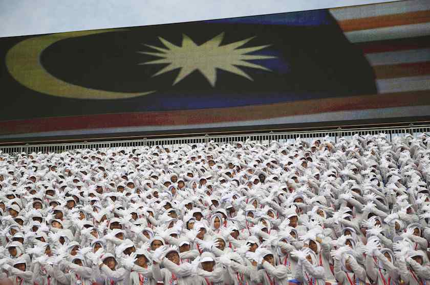 Performers stand in front of a large screen showing the national flag during Merdeka Day celebrations in Kuala Lumpur August 31, 2014. u00e2u20acu201d Reuters pic