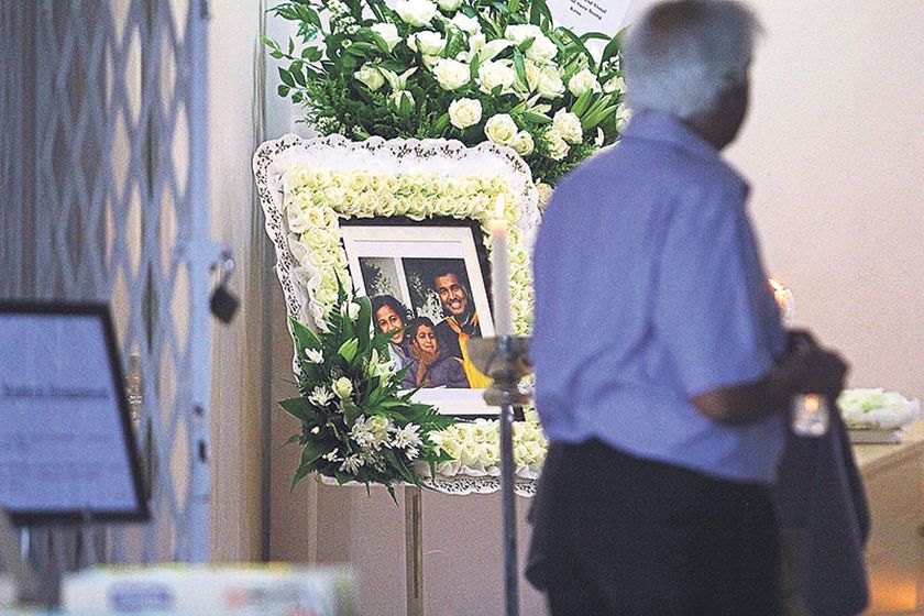 A man walks past a picture of Paul, Mabel and Matthew at Paulu00e2u20acu2122s family home in Bangsar yesterday. u00e2u20acu201d Picture by Hari Anggara