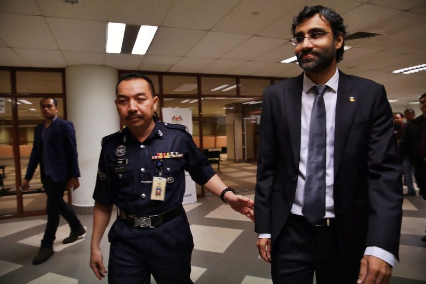 A policeman escorts PKR vice-president N. Surendran out from the Sessions Court at Jalan Duta Court Complex in Kuala Lumpur, August 19, 2014. u00e2u20acu2022 Picture by Saw Siow Feng