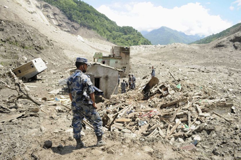 A rescue team from the Armed Police Force stands near damaged houses in the landslide area in Sindhupalchowk district, August 2, 2014. u00e2u20acu201d Reuters pic 