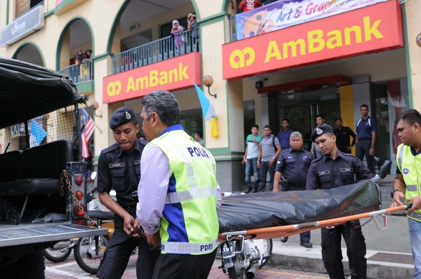 Police remove the body of a would-be robber who was shot dead by a security guard after he threatened to set a bank on fire, August 28 2014. u00e2u20acu201d Picture by K.E. Ooi