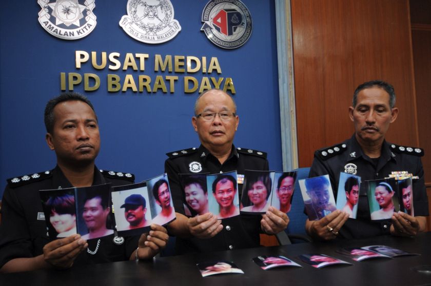 The police showing photos, extracted from the video clip, of the people believed to be involved in the nude event, August 7, 2014. u00e2u20acu201d Picture by K.E. Ooin