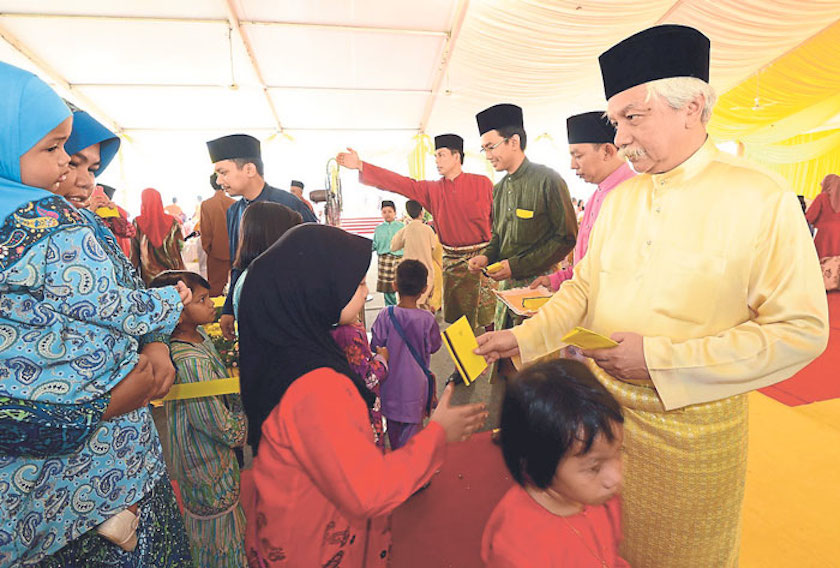Yang diPertuan Besar Negri Sembilan Tuanku Muhriz gives out duit raya to children during the Raya open house at Istana Seri Menanti July 28, 2014. u00e2u20acu201d Picture by Malay Mail