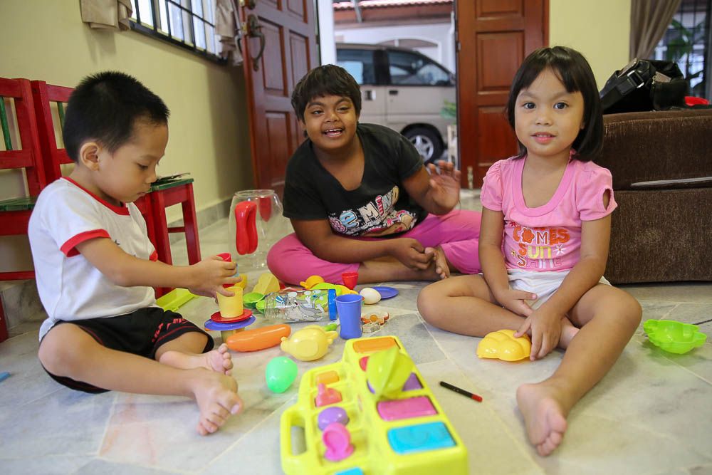 Isaac, Abigail and Isabella playing in their living room at Agape Home in Bukit Beruntung. — Picture by Choo Choy May