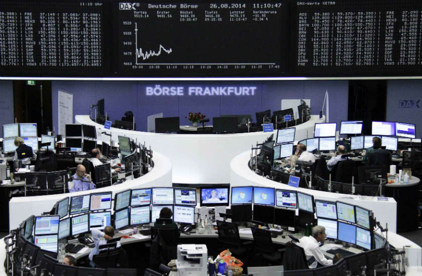 Traders are pictured at their desks in front of the DAX board at the Frankfurt stock exchange. u00e2u20acu201d Reuters pic