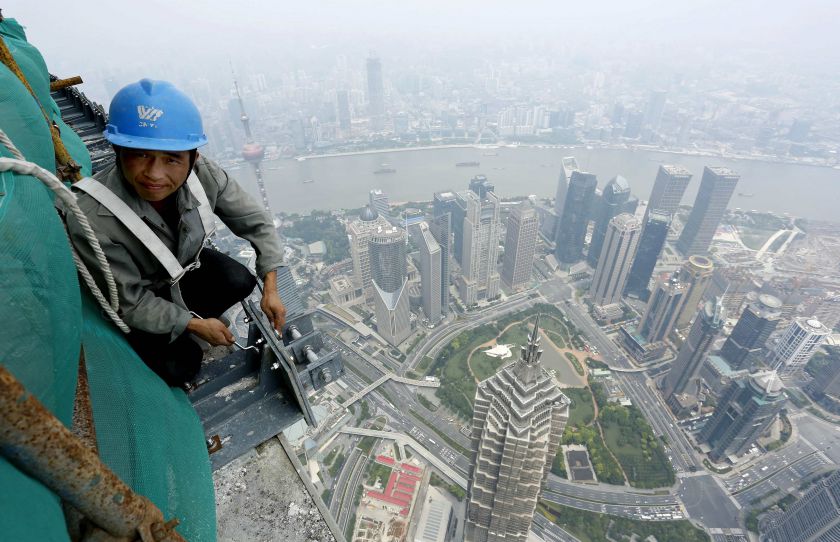 A labourer works atop the Shanghai Tower, the worldu00e2u20acu2122s second tallest, at the financial district of Pudong. Data released on August 5, 2014 showed growth in China's services sector slipped to a six-month low in July. u00e2u20acu201d Reuters pic