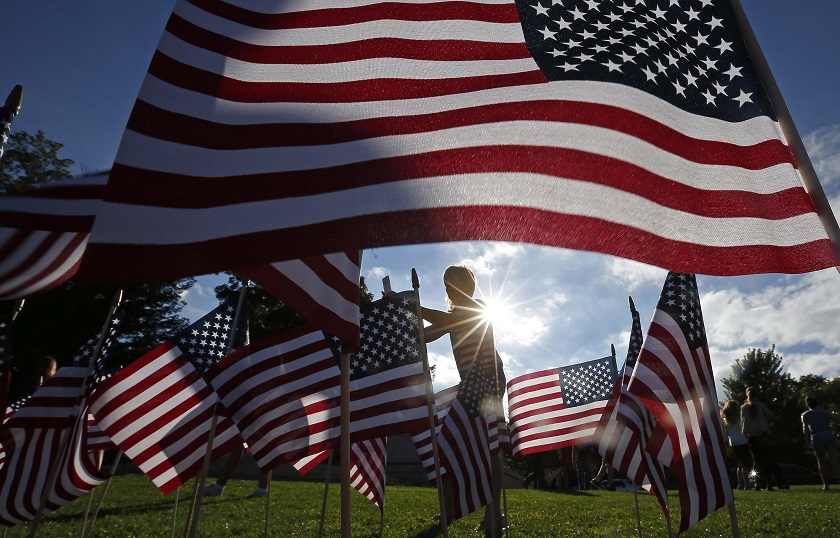 A woman stands among some of the 3,000 flags placed in memory of the lives lost in the September 11, 2001 attacks, at a park in Winnetka, Illinois September 10, 2014. u00e2u20acu201d Reuters pic