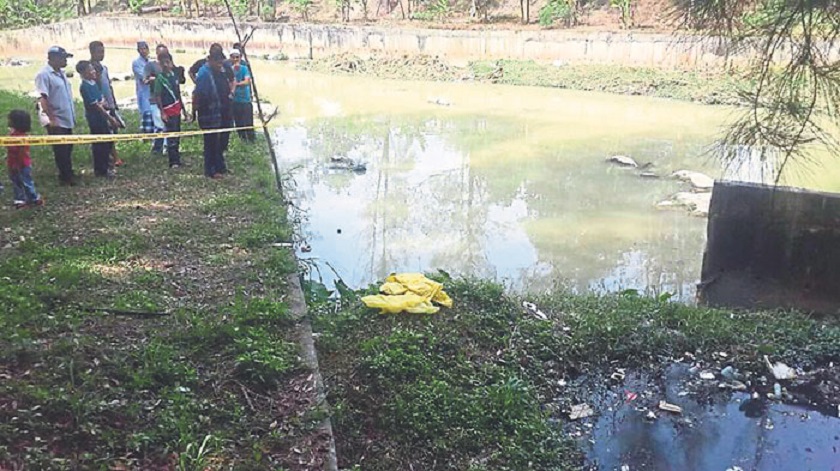 Residents look at the spot where the body of a baby boy was found in Taman Wilayah, Sentul.u00e2u20acu201d Picture by Malay Mail