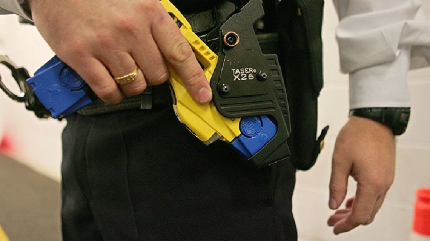 A British police officer holsters a taser gun. u00e2u20acu201d AFP pic