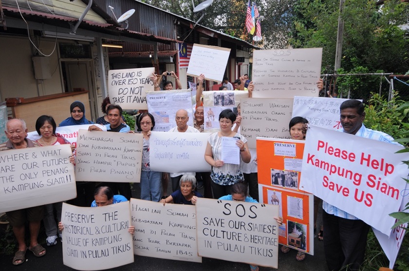 Residents of the Siamese village hold up placards as a show of protest against the demolition of the 200-year-old village in Penang, on September 24, 2014. u00e2u20acu201d Picture by K.E. Ooi 
