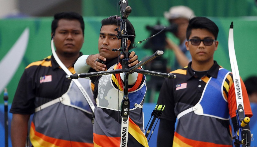 Malaysiau00e2u20acu02dcs Haziq Bin Kamaruddin (left) and Atiq Bazil Bin Bakri (right) watch as Khairul Anuar Bin Mohamad shoots during their menu00e2u20acu2122s recurve team gold medal archery match during the 17th Asian Games in Incheon September 28, 2014. u00e2u20acu201d Reuters pic